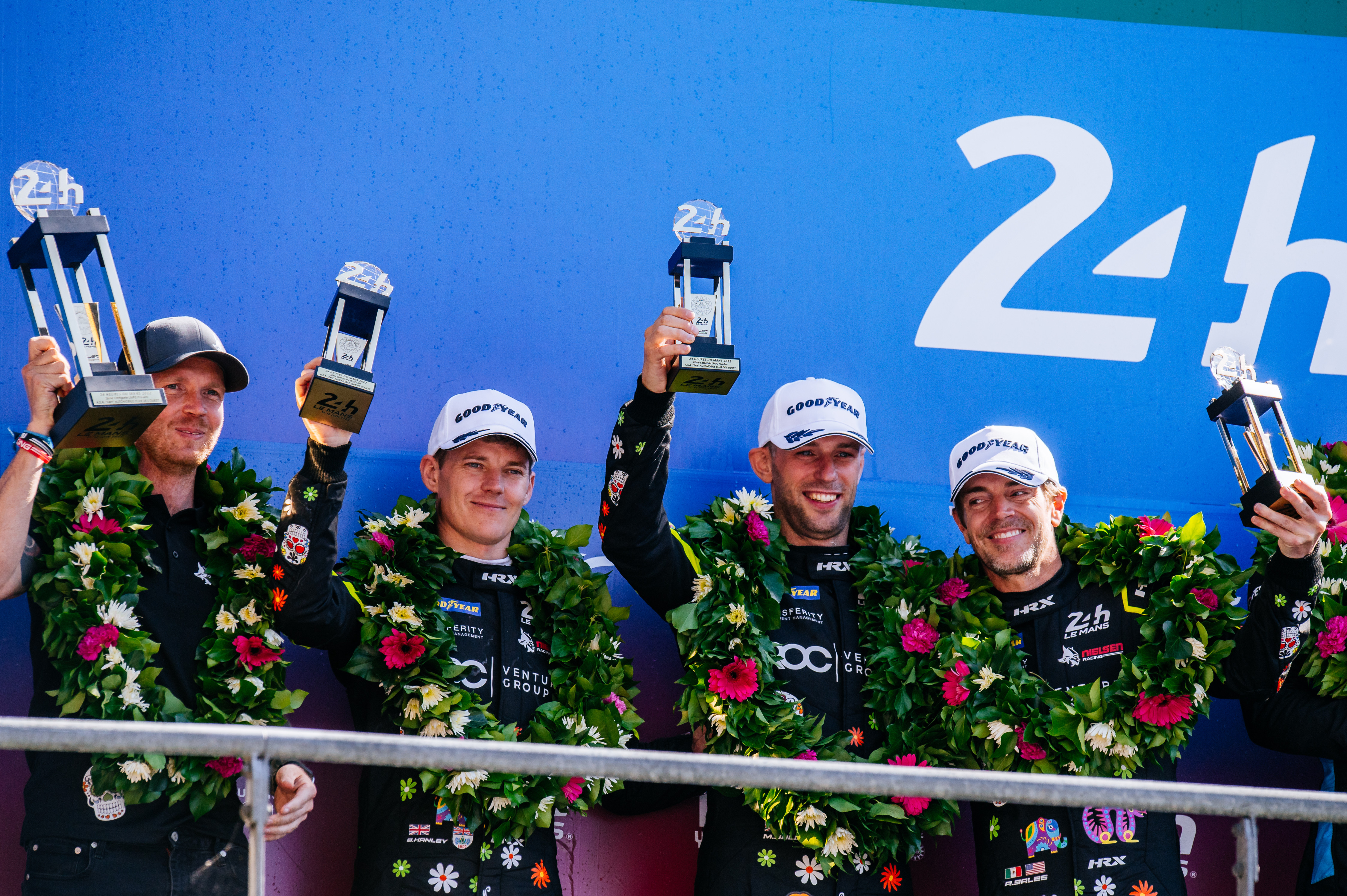 Matt Bell racing driver on the Le Mans 24 Hours podium with his teammates and trophy