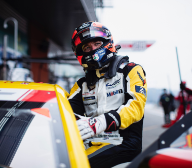 Racing Driver Oliver Gavin getting into a yellow corvette racing car wearing his helmet