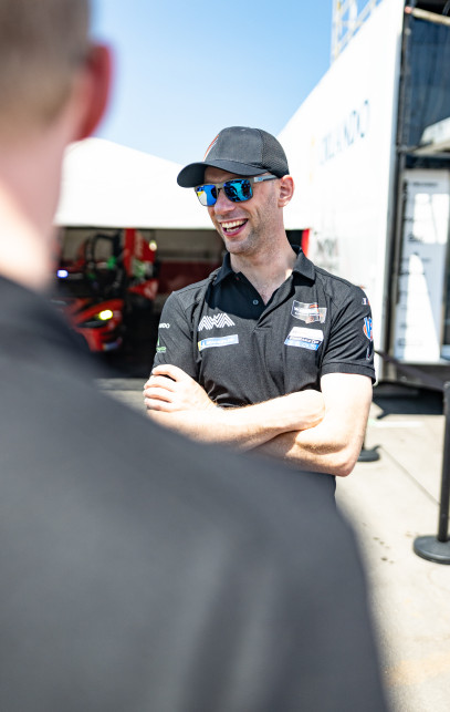 Racing driver chatting with team members
