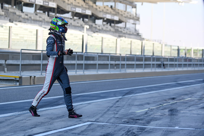 Colin Braun walking across the pit lane in his race suit and helmet