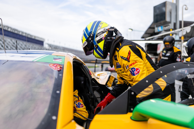 Matt Bell racing driver strapping team mate into corvette racing car