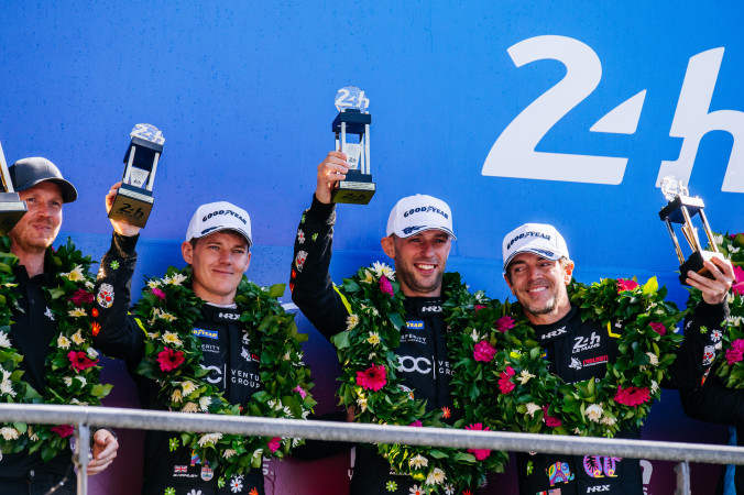 Matt Bell racing driver on the Le Mans 24 Hours podium with his teammates and trophy